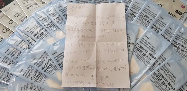 경남 함안군은 군북초등학교 1학년에 재학 중인 이윤아양이 어려움을 겪는 이웃을 위해 용돈으로 산 마스크 50매를 기탁했다고 17일 밝혔다. 사진은 이 양이 기탁한 마스크와 손편지. 함안군 제공