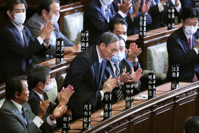 스가 요시히데 일본 총리가 16일 중의원 본회의 지명선거에서 신임 총리로 확정된 뒤 일어나 인사하고 있다. 도쿄=AP 연합뉴스