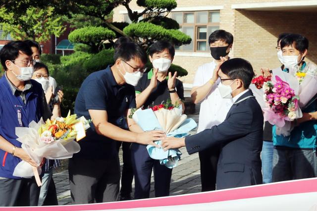 18일 충남 서산시 해미면 서산고등학교 현관 앞에서 열린 '전교조 교사 복직 환영식'에서 이 학교에 복직한 김종현 교사(왼쪽 두 번째)가 김익권 전교조 서산시지부장으로부터 꽃다발을 받고 있다. 김 교사의 복직은 지난 3일 '전교조 법외노조 처분이 위법하다'는 대법원의 파기 환송 결정에 따른 것이다. 서산=연합뉴스