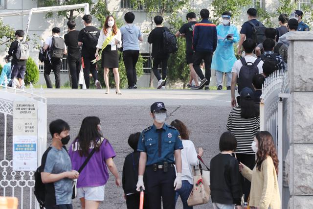 순경공채 필기시험이 치러진 19일 오전 서울 중구 한양공업고등학교에서 응시생들이 시험장으로 향하고 있다. 시험장 입구에서는 방역 관계자가 응시생들과 문답을 나누고 있다. 경찰은 신종 코로나바이러스 감염증(코로나19) 확산 방지를 위해 시험 전과 후 고사장에 대한 방역을 실시하고 응시자 사이 1.5m 이상 거리 두기 등을 실시한다. 뉴스1