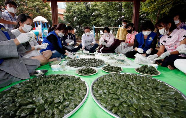 21일 오전 광주 북구 일곡어린이공원 내 쉼터에서 문인 북구청장과 바르게살기운동 광주북구협의회원, 이주여성들이 추석을 맞아 마스크를 쓰고 송편을 빚고 있다. 이날 만든 송편은 관내 이주여성 100세대에 전달할 예정이다. 광주 북구 제공