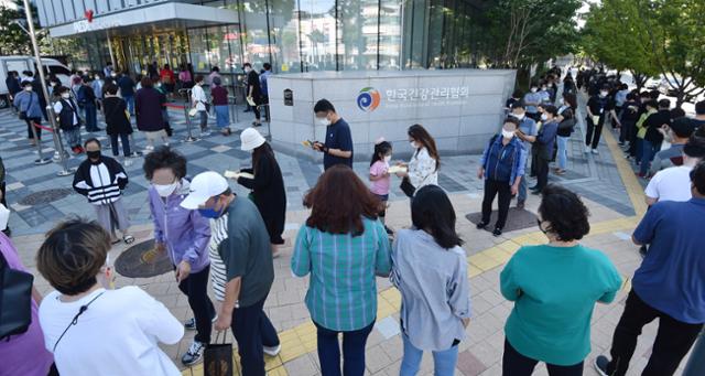 22일 경기 수원시 장안구 한국건강관리협회 경기도지부에 인플루엔자(독감) 백신 유료접종을 맞으려는 시민들이 길게 줄 서 순서를 기다리고 있다. 질병관리청은 만 13~18살(중고생) 대상으로 무료 예방접종하려던 백신에서 유통 과정상 문제가 발견돼 백신접종 중단을 긴급 공지했다. 뉴시스