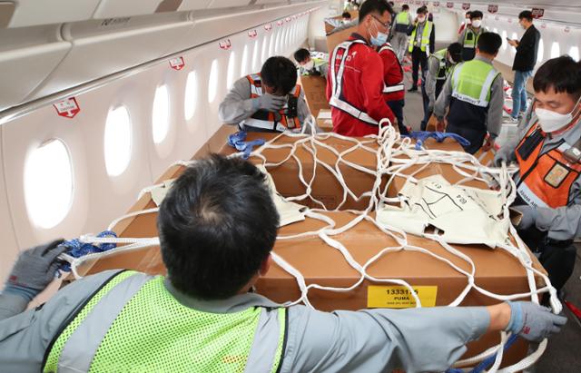 24일 오후 인천국제공항 1터미널에서 아시아나항공 관계자들이 A350 여객기에 화물을 탑재하고 있다. 아시아나항공은 A350-900 여객기 1대의 이코노미 좌석 283석을 화물탑재 공간으로 개조했다. 이번 개조로 5톤의 추가 화물을 적재해 편당 23톤의 화물 수송이 가능하다. 영종도=공항사진기자단