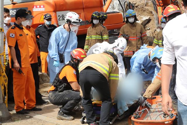 24일 오전 경기 안양시 동안구 호계동의 한 아파트 공사현장에서 옹벽이 무너지면서 2명이 매몰됐다. 119구조대가 매몰됐던 작업자를 구조하고 있다. 뉴스1