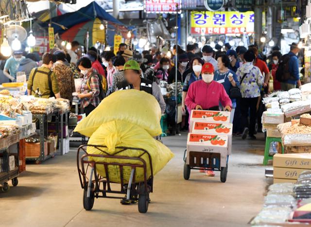 추석을 일주일 앞둔 24일 오전 서울 동대문구 경동시장이 예년에 비해 인파가 줄은 가운데 사람들이 운반 카트를 이용해 물건을 나르고 있다. 홍인기 기자