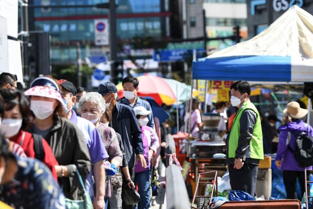 코로나19 확산 우려로 인해 12회동안 휴장한 모란장이 다시 열린 24일 오전 방문객이 장에 들어가기 위해 줄 서 있다. 이한호 기자