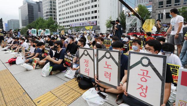 인천공항공사 직원들과 취업준비생 등 청년들이 8월 서울 중구 예금보험공사 앞에서 열린 ‘투명하고 공정한 정규직 전환 촉구 문화제’에서 "졸속으로 진행된 인천공항공사 비정규직의 정규직 전환을 즉각 중단하라"고 주장하고 있다. 뉴스1