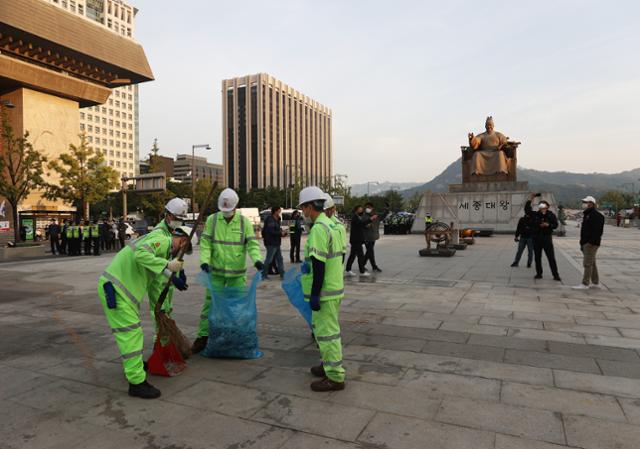 29일 오전 서울 종로구 광화문광장에 차려졌던 '고(故) 백선엽 장군 분향소'가 철거된 자리에서 구청 청소행정과 관계자들이 청소를 하고 있다. 서울시는 이날 오전 분향소 텐트와 집회 물품 철거를 충돌없이 마쳤다. 연합뉴스