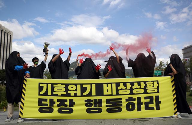 지난 25일 오전 서울 광화문 광장에서 기후위기비상행동 관계자들이 '글로벌 기후 행동의 날'을 맞아 기자회견을 하고 기후 재난 안전망 강화, 해외 석탄 발전 투자 중단 등을 촉구하는 퍼포먼스를 하고 있다. 연합뉴스