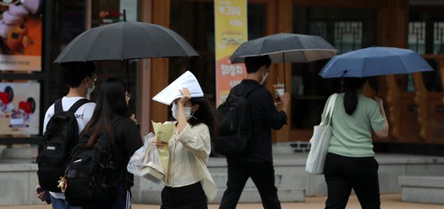 지난달 17일 전북 전주시 전북대학교에서 빗방울이 떨어지자 우산을 챙기지 못한 시민이 인쇄물로 비를 막으며 발걸음을 재촉하고 있다. 전주=뉴스1