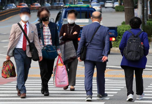 서울 지역 아침 기온이 16도까지 떨어지며 비교적 쌀쌀한 날씨를 보인 4일 서울 종로구 세종로네거리에서 긴팔 차림의 시민들이 발걸음을 옮기고 있다. 뉴시스