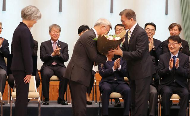 강경화 외교부 장관의 배우자인 이일병 연세대 명예교수의 요트 구입 여행이 빈축을 사고 있다. 사진은 2017년 문재인 대통령이 청와대에서 강경화 신임 외교부장관의 남편에게 꽃다발을 주고 있는 모습. 한국일보 자료사진