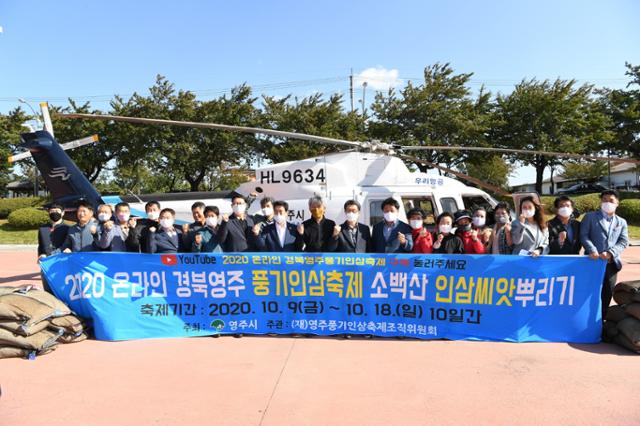 경북 영주시 풍기인삼축제 관계자들이 5일 소백산 풍기인삼 씨앗 뿌리기 퍼포먼스에 앞서 헬기 앞에서 기념사진을 찍고 있다. 영주시 제공