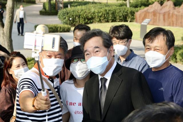 이낙연 더불어민주당 대표가 1일 경남 김해 봉하마을에서 고(故) 노무현 전 대통령 묘소를 찾은 시민들과 기념 촬영을 하고 있다. 뉴스1