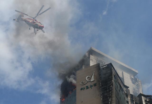 8일 오후 울산시 남구 한 주상복합아파트에서 난 화재가 9일 오전까지 꺼지지 않아 헬기가 동원돼 진화 작업을 하고 있다. 연합뉴스