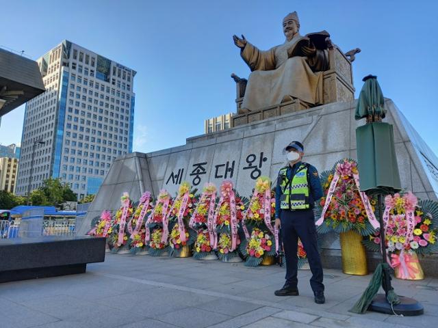 한글날인 9일 서울 종로구 광화문광장에 위치한 세종대왕 동상이 불법 집회를 막으려는 경찰과 한글날을 기념하는 화환에 둘러싸여 있다. 김정현 기자