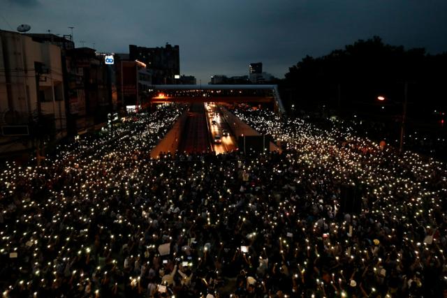 19일 태국 수도 방콕의 한 교차로에 모인 대규모 시위대가 일제히 휴대폰 불빛을 비추며 쁘라윳 짠오차 총리의 퇴진을 요구하고 있다. 방콕=AP 뉴시스