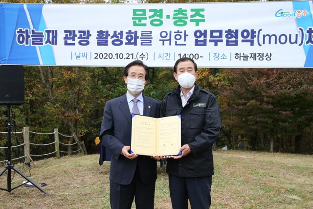 조길형(오른쪽) 충주시장과 고윤한 문경시장이 21일 오후 하늘재 정상에서 하늘재 관광활성화 업무협약을 했다. 충주시 제공