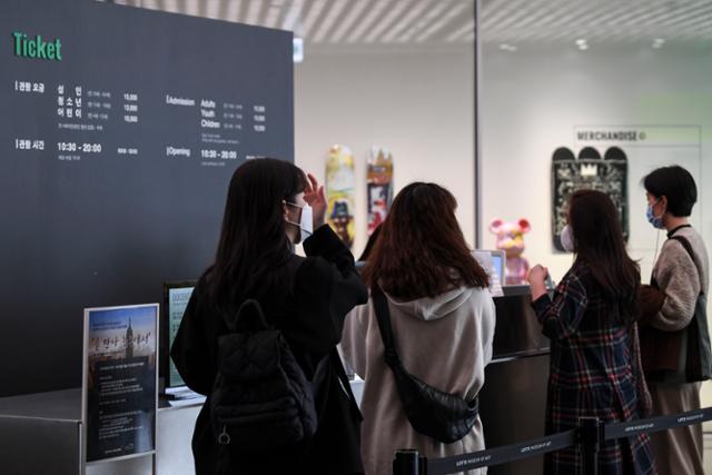 정부가 지난 8월 코로나19 재확산으로 잠정 중단한 소비쿠폰 발급을 전시·영화를 포함한 일부 업종에 대해 재개한 22일 오후 서울 송파구 롯데뮤지엄에서 열린 장 미쉘 바스키아 전시 관람객이 입장권을 발권하고 있다. 이한호 기자