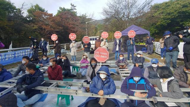 국방부가 22일 성주 사드 기지에 공사 장비를 반입하려 하자 주민 70여명이 사드기지 입구 진밭교에서 사다리형 구조물에 몸을 넣어 반대시위를 준비하고 있다. 성주=연합뉴스