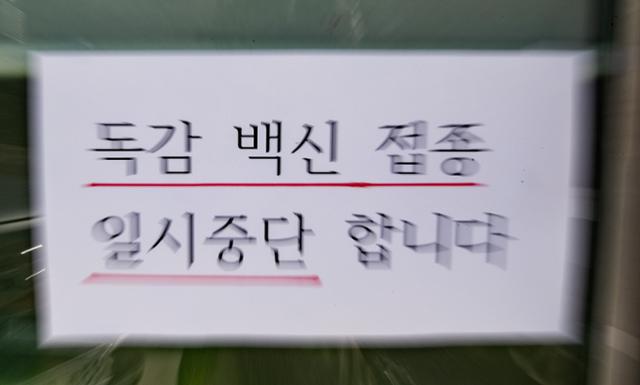 독감 백신을 접종한 뒤 사망자가 잇따라 나오면서 시민들이 불안감이 커지고 있다. 대한의사협회는 독감 국가 예방접종 사업을 23일부터 29일까지 일주일간 잠정 중단하고 최근 발생한 사망사례와의 인과 관계를 밝히기를 촉구했다. 사진은 이날 오후 서울의 한 병원에 독감 예방접종 일시중단 안내문이 게시돼 있다. 뉴스1