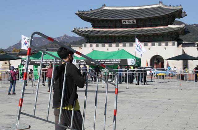 23일 오후 서울 광화문 광장에서 우리공화당이 설치한 '박정희 전 대통령 분향소 명목의 천막' 인근에 서울시 관계자들이 사회적 거리 두기를 위한 펜스를 설치하고 있다. 우리공화당은 "'구국의 영웅 박정희 대통령 서거 41주기 추도 분향소'를 세웠다"며 "24일부터 26일 오후 6시까지 운영하겠다"고 밝혔다. 이에 대해 서울시는 "코로나19 방역 문제로 2월부터 광화문광장은 사용 승인을 하지 않고 있다"며 "오늘 중 천막 철거 관련 예고를 할 것"이라고 밝혔다. 연합뉴스