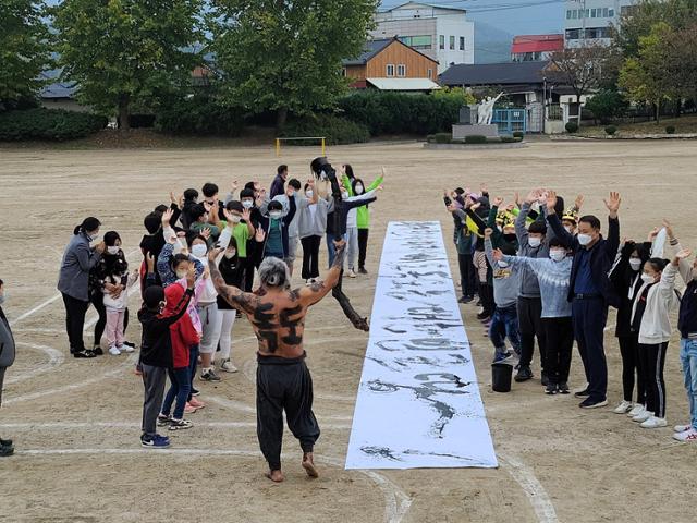 경주 아화초 학생들과 쌍산 김동욱 서예가가 독도 사랑 퍼포먼스를 펼치고 있다. 아화초 제공