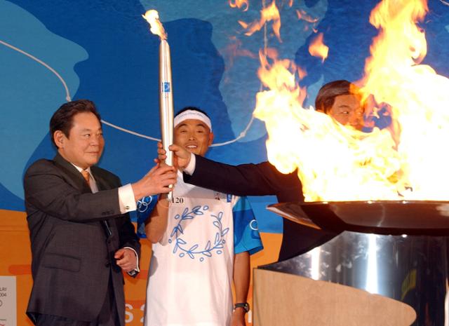 고 이건희 삼성전자 회장(IOC위원)과 성화봉송 최종주자인 마라톤 이봉주 선수가 2004년 6월 서울 시청 앞 성화대에 불을 점화하고 있다. 한국일보 자료사진