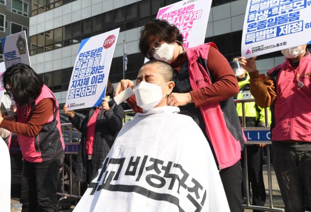 민주노총 서비스연맹 전국학교 비정규직 노조 회원들이 27일 서울 여의도 더불어민주당사 앞에서 11.6 돌봄파업 선포 및 초등돌봄전담사 집단삭발 기자회견을 하고 있다. 왕나경 인턴기자