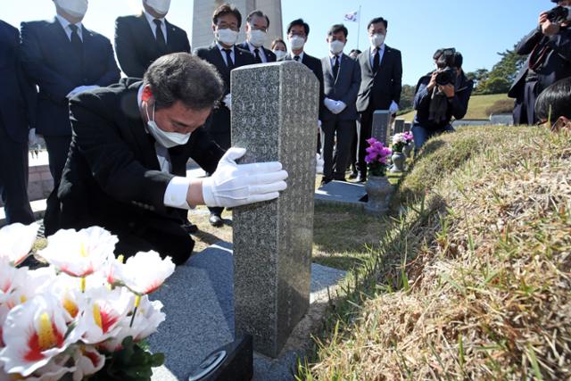 이낙연 더불어민주당 대표가 24일 오전 광주 북구 운정동 국립5.18민주묘지에서 참배를 마친 뒤 윤상원 열사 묘비를 잡고 고개를 떨구고 있다. 뉴스1