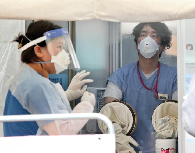 28일 오후 서울 중구 국립중앙의료원에 마련된 선별진료소에서 의료진들이 내원객에게 코로나19 검체 채취 준비를 하고 있다. 뉴스1