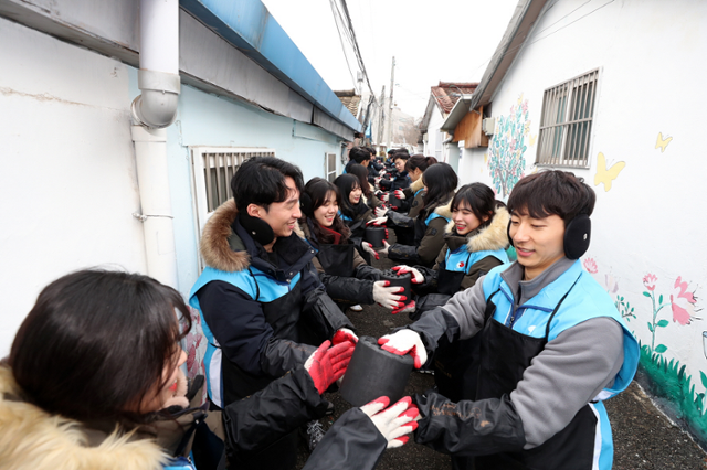 지난 1월 8일 경기 광명시 소하동에서 대우건설 신입사원들이 저소득층 가구에 전달할 연탄을 한 장씩 옮기고 있다. 대우건설 제공