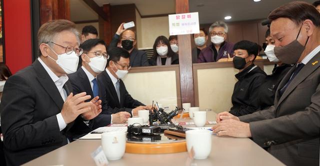 이재명 경기지사가 17일 전북 군산시를 찾아 강임준 군산시장, 소상공인 등과 공공배달앱에 대해 대화를 나누고 있다. 연합뉴스