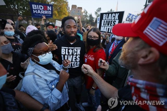 미국 유타주 솔트레이크시티에서 도널드 트럼프 대통령 지지자와 조 바이든 지지자가 대선 직전 맞서고 있다. 솔트레이크시티=AP연합뉴스