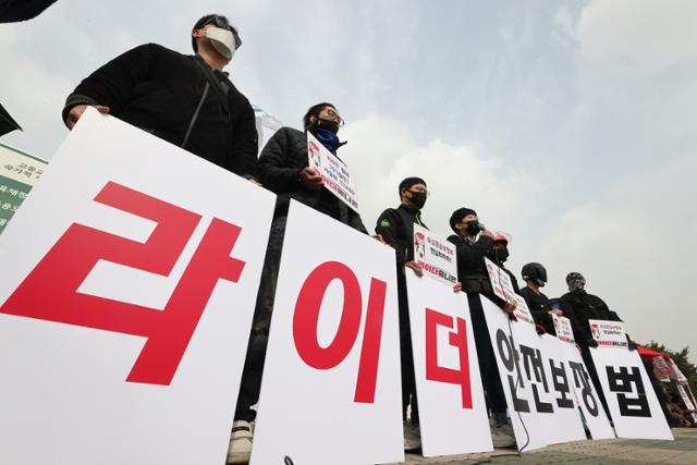 근로기준법 준수가 아니라 적용을 요구해야 하는 게 플랫폼 노동자들의 현실이다. 그들에게는 지켜 달라고 할 근로기준법 자체가 없다. 지난달 22일 국회 앞에서 라이더유니온 관계자들이 며칠 전 정부가 발표한 배달이륜차보험료 대책을 비판하는 기자회견을 하고 있다. 연합뉴스