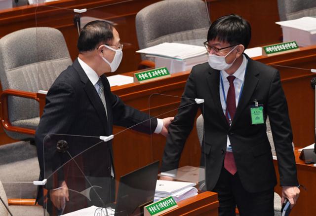 홍남기(왼쪽) 경제부총리 겸 기획재정부장관이 5일 국회에서 열린 예산결산특별위원회에서 김상조 청와대 정책실장과 인사하고 있다. 연합뉴스