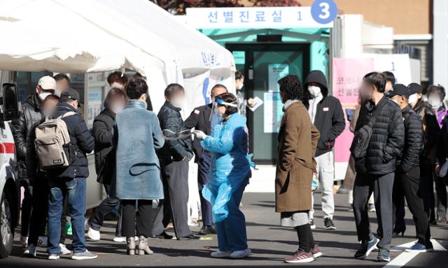 일요일인 8일 오전 서울 중구 국립중앙의료원에 마련된 선별진료소에서 의료진이 코로나19 검체 채취를 위해 내원한 시민들을 안내하고 있다. 뉴스1