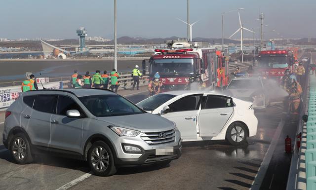 10일 오후 인천시 중구 영종대교에서 열린 '인천국제공항고속도로 2020년 겨울철 폭설대응 유관기관 합동 모의훈련'에서 소방대원들이 사고 차량에 난 불을 진화하는 훈련을 하고 있다. 이번 훈련은 폭설로 대교 위에서 교통사고가 난 상황을 가정해 진행됐다. 연합뉴스