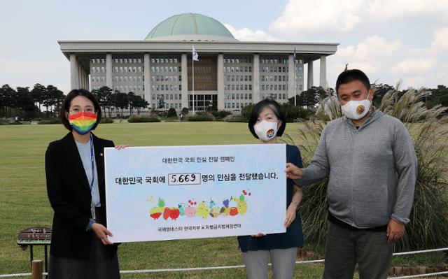 장혜영 (왼쪽 첫번째) 정의당 의원이 9월 28일 국회 본청앞에서 열린 대한민국 국회 민심전달 캠페인에서 윤지현(가운데) 국제앰네스티 한국지부 사무처장, 이종걸 차별금지법제정연대 공동대표에게 차별금지법 제정을 촉구하는 민심을 전달받고 있다. 뉴스1