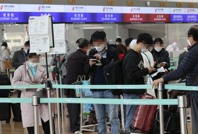 지난달 30일 오전 인천국제공항 제1여객터미널 중국 베이징행 에어차이나(중국국제항공) 체크인 카운터에서 승객들이 탑승 수속을 하고 있다. 연합뉴스