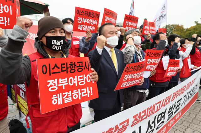 10월 21일 오전 서울 국회 앞에서 열린 이스타항공 정리해고사태 정부여당 해결 촉구 범시민사회 성명 발표 기자회견에서 민주노총 공공운수노조 등을 비롯한 참가자들이 관련 구호를 외치고 있다. 연합뉴스