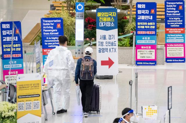 15일 인천국제공항 1터미널에서 입국자가 봉호복을 입은 공항 관계자의 안내를 받으며 이동하고 있다. 코로나19 장기화로 여행길이 막히면서 여행업체의 경영 악화도 길어지고 있다. 연합뉴스