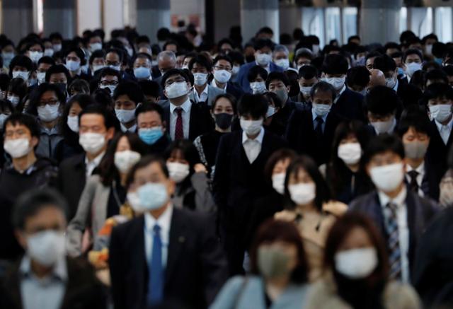 지난 13일 일본 도쿄의 시나가와 역에서 직장인들이 마스크를 착용하고 출근하고 있다. 로이터 연합뉴스