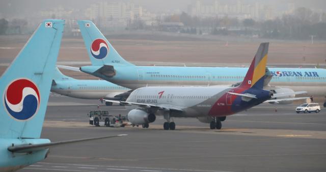 지난 16일 서울 강서구 김포국제공항 국내선청사 전망대에서 바라본 계류장에 대한항공 여객기 사이로 아시아나항공 여객기가 이동하고 있다. 뉴시스