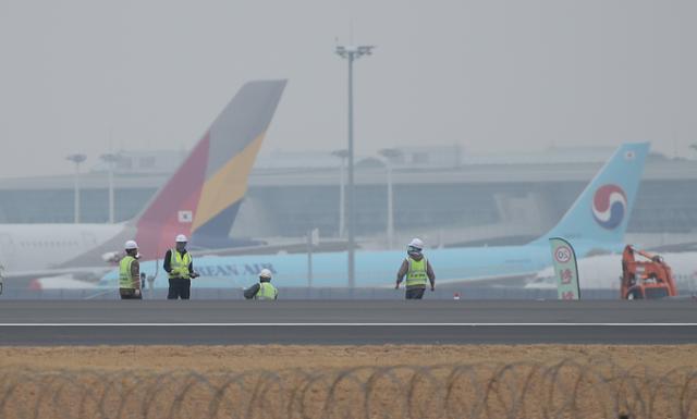 17일 오후 인천국제공항 제4활주로 공사현장 뒤로 대한항공과 아시아나항공 여객기들이 세워져 있다. 영종도=연합뉴스