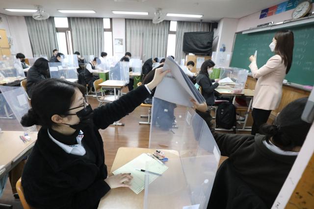 2021학년도 대학수학능력시험(12월 3일)을 앞두고 대구지역 고3 수험생들의 마지막 학력평가가 실시된 18일 오전 대구중앙고등학교 3학년 교실에서 수험생들이 문제지를 전달하고 있다. 대구=뉴스1