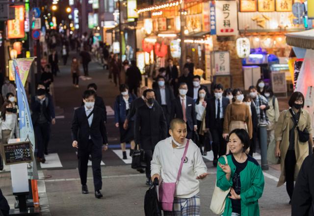 일본 도쿄 도심의 한 거리에 19일 마스크를 쓴 사람들이 걸어가고 있다. 도쿄=AP 연합뉴스