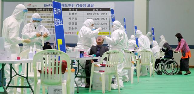 전북 전주시가 요양병원 등의 신종 코로나바이러스 감염증(코로나19)에 취약한 고위험군 시설을 대상으로 전수조사를 시작한 11일 전북 전주시 전주화산체육관 선별진료소에서 의료진들이 시민들을 대상으로 검체 채취를 하고 있다.