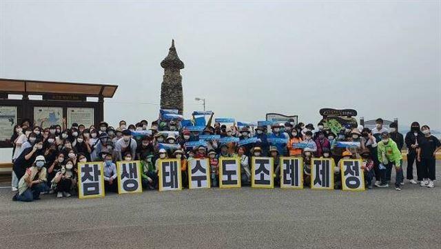 전남 순천시 생태도시조례제정100인위원회가 지난 5월 별량면 화포해변 선착장에서 발대식을 가진 뒤 기념촬영을 하고 있다.