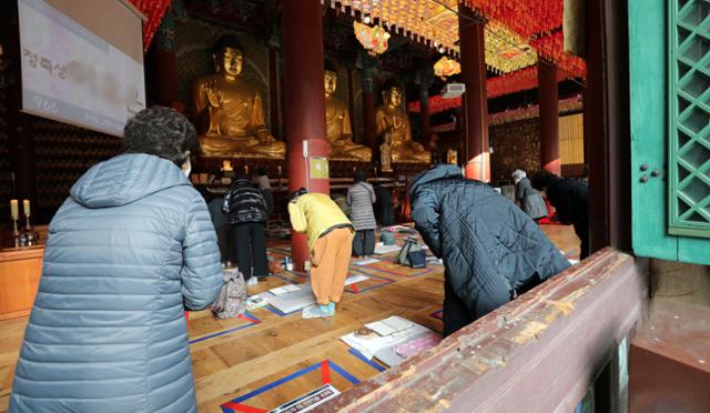 대학수학능력시험이 일주일 앞으로 다가온 26일 오후 서울 종로구 조계사 대웅전에서 불교 신자를 비롯한 학부모들이 거리를 두며 기도를 하고 있다. 뉴스1